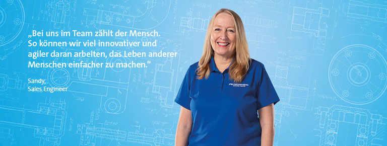 Eine in die Kamera lächelnde, blonde Frau, die ein blaues Shirt trägt und vor einem blauen Hintergrund steht. Im linken Bildteil ist ein Zitat hinterlegt.