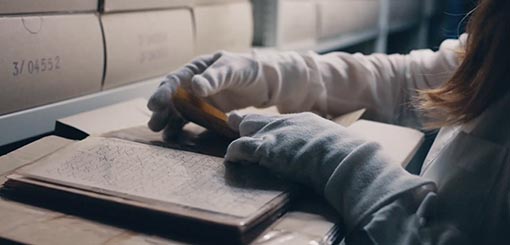 Nahaufnahme einer Archivrecherche von historischen Dokumenten