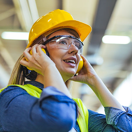 Female Factory Worker Wearing Safety Gear in an Industrial Setting