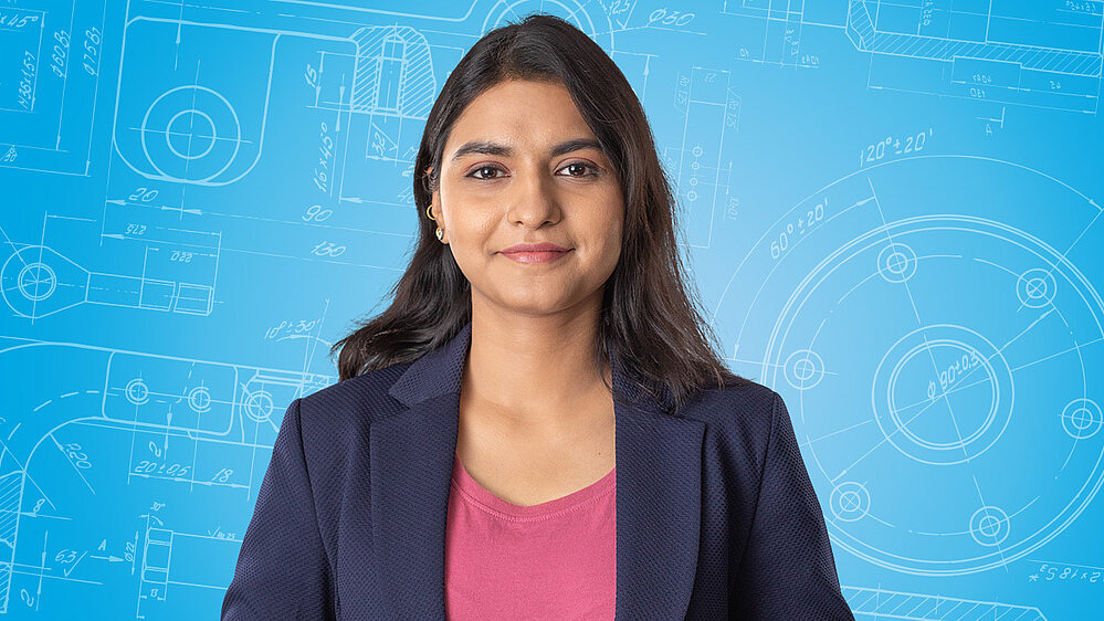 Portrait of a female person shown in the center of the picture against a blue background.