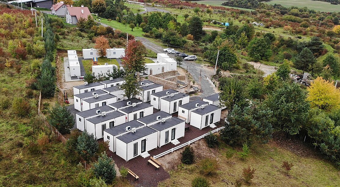 Vogelperspektive auf Bungalows, die in einer grünen Landschaft stehen