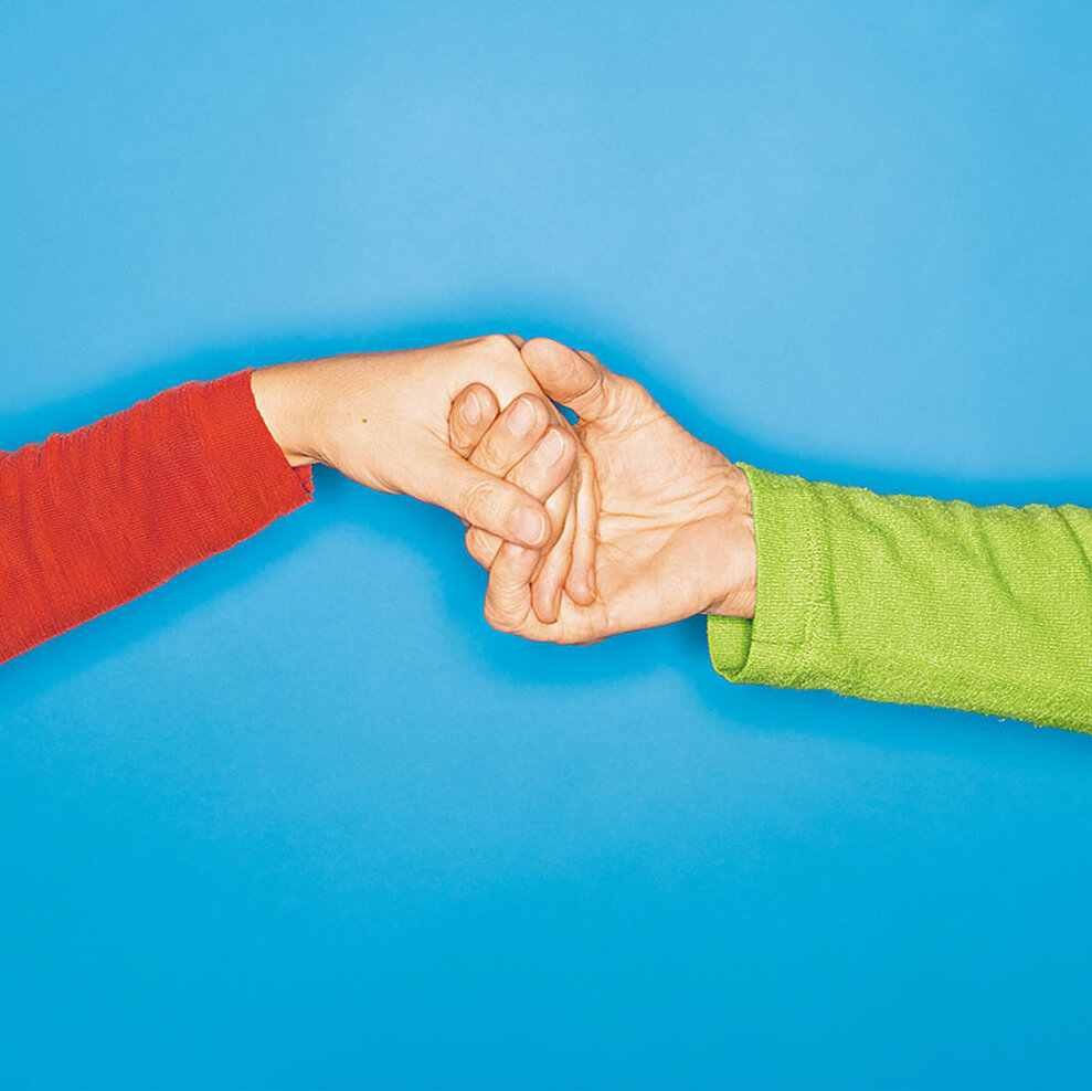 Photo of two hands holding each other