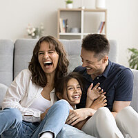 Ein weißer Luftfilter in einem Raum neben einer Pflanze, der blaue Partikel aus der Luft filtert