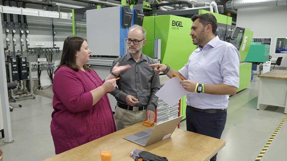 Zwei Männer und eine Frau stehen sich gegenüber und reden miteinander