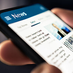 Close up of a phone screen showing a blurred news article