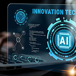 Detail of laptop and mouse pen. Above it is a virtual screen with diagrams and references to the integration of AI in development and processes.