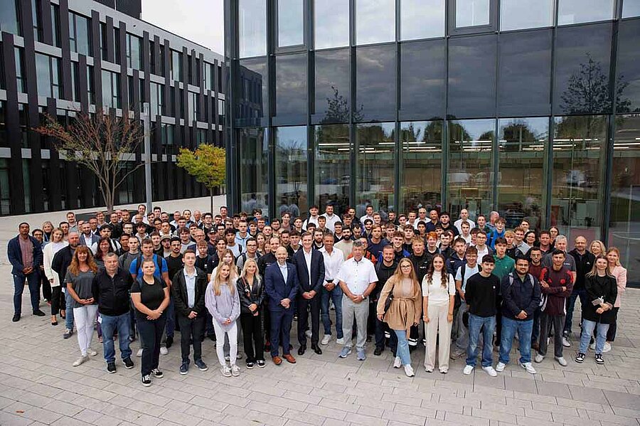 A large group of young people standing in front of a building