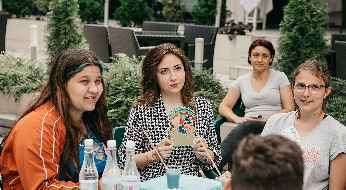 junge Menschen, die an einem Tisch sitzen und miteinander reden