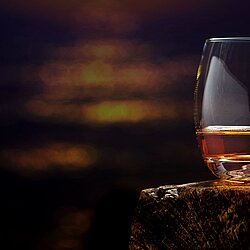 a glass of whisky and a dark brown background