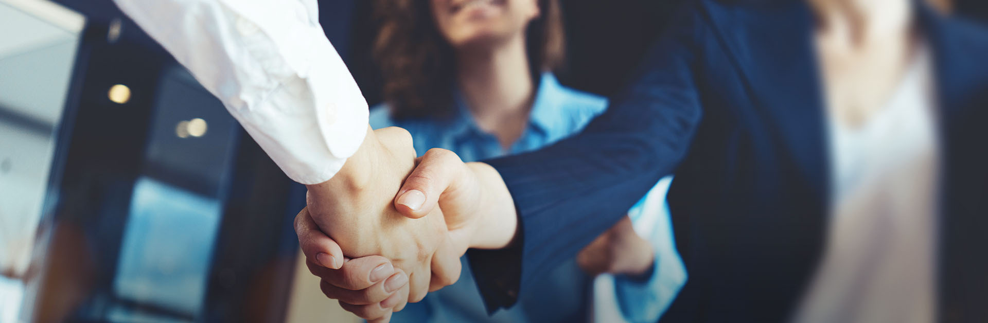 Junge Geschäftsleute beim Handschlag im Büro