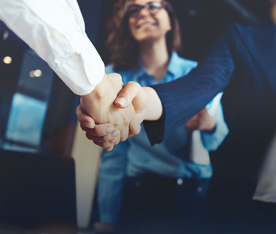 Junge Geschäftsleute beim Handschlag im Büro